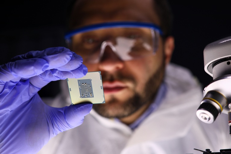 Scientist holding microchip in lab, representing electrowetting technology for microfluidics and digital displays enabled by amorphous fluoropolymers.