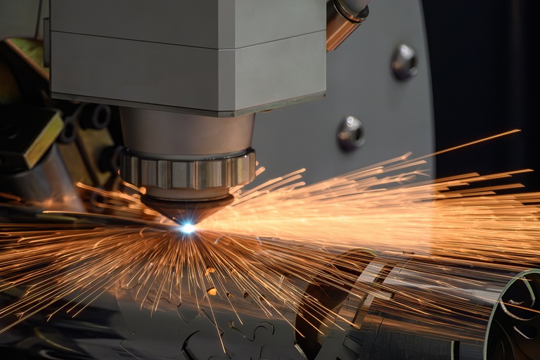 High-power fiber laser cutting metal with visible sparks, demonstrating industrial applications of high-power laser optical fiber systems.