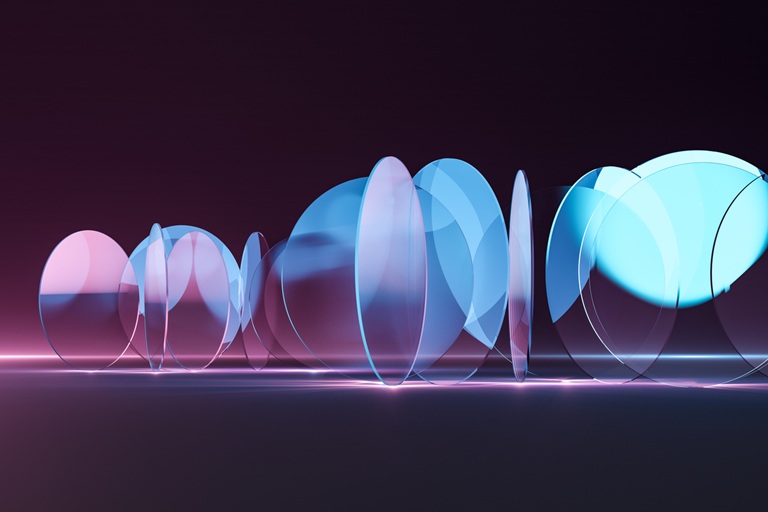 Abstract photonics image showing cyan-violet light passing through transparent optical materials, suggesting low-index coatings, refractive index control, and optical system design.